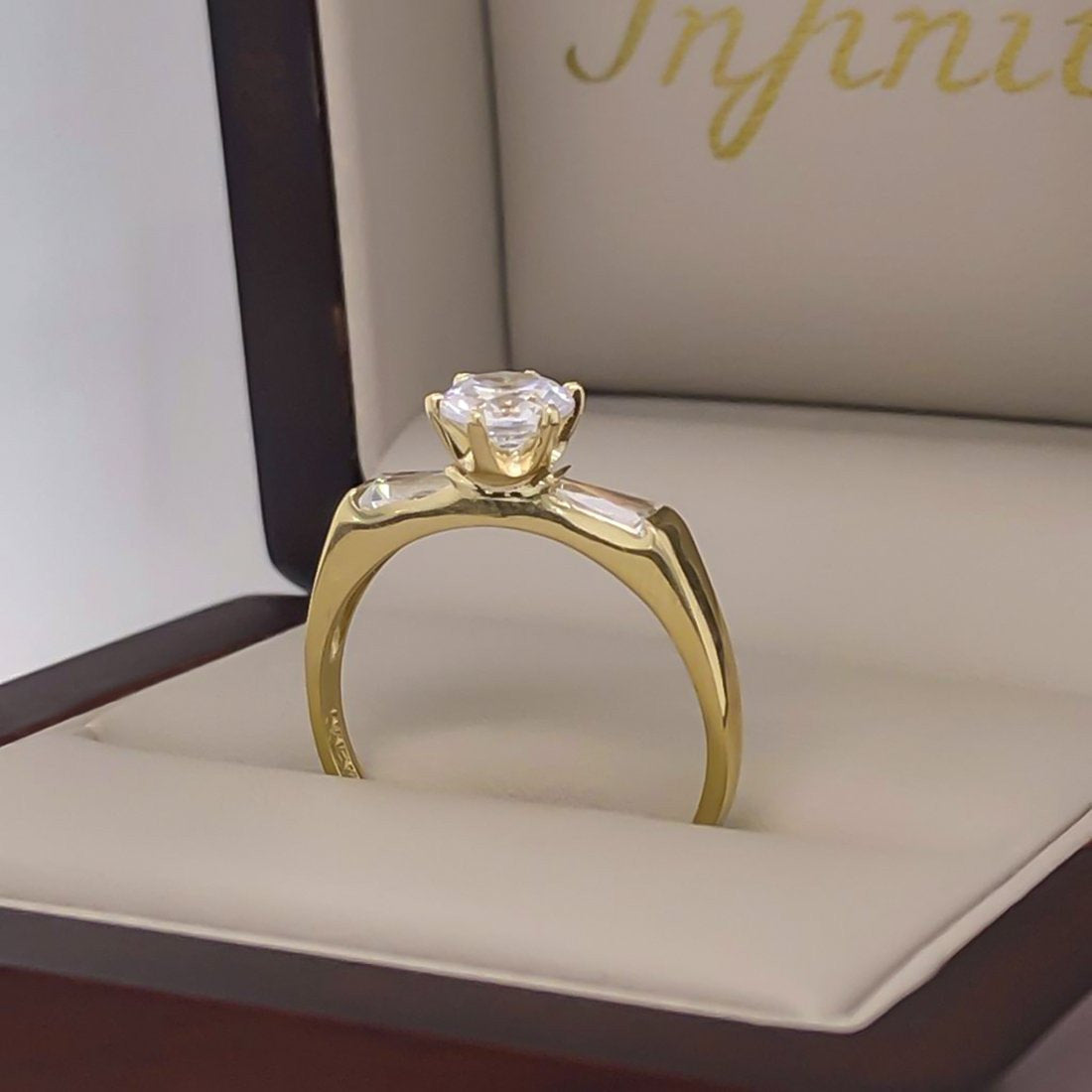 Anillo Oro 10k, Zirconia Central de 5.5 mm, Baguettes Laterales - Infiniti Joyas