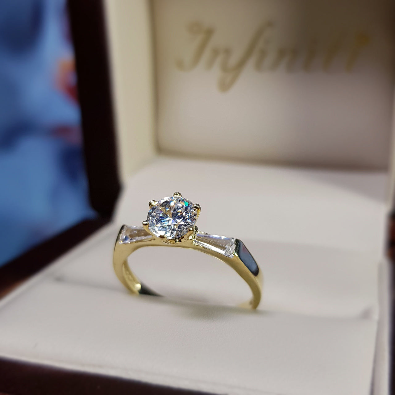 Anillo Oro 10k, Zirconia Central de 5.5 mm, Baguettes Laterales - Infiniti Joyas